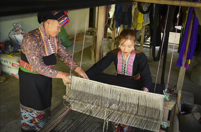 Phụ nữ dân tộc Lào truyền dạy nghề dệt vải thổ cẩm cho thế hệ trẻ. Ảnh: Xuân Tư – TTXVN