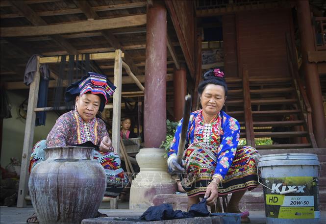 Công đoạn nhuộm chàm vải. Ảnh: Xuân Tư – TTXVN