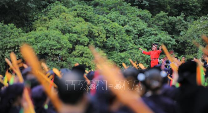  Nhạc trưởng Đinh Thị Niêm (áo đỏ) chỉ huy màn công diễn hát Then đàn Tính. Ảnh: Chu Hiệu-TTXVN.