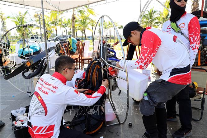 Pilots check their paragliding equipment carefully before the flight. VNA Photo: Đức Hiếu