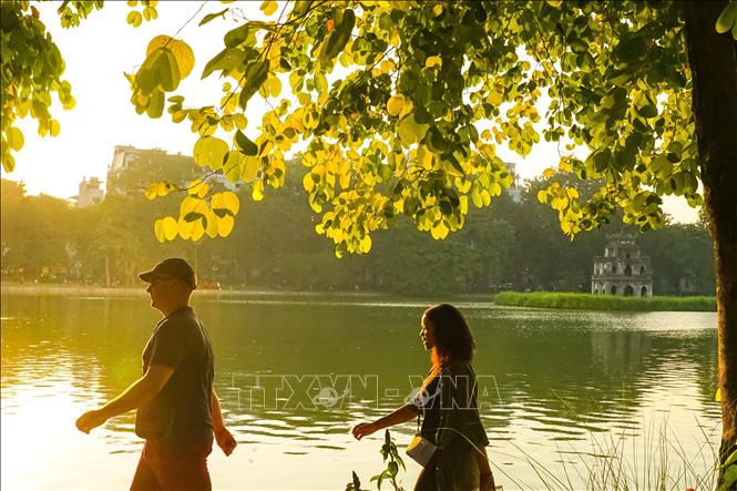 Khánh du lịch thư thái đi dạo bên hồ Hoàn Kiếm. Ảnh: Khánh Hoà - TTXVN
