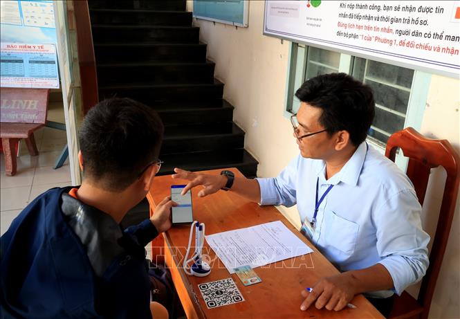 Hướng dẫn người dân cài đặt ứng dụng Tây Ninh Smart. Ảnh: Hồng Đạt - TTXVN

