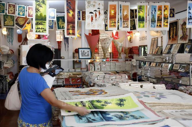 Du khách nước ngoài rất thích thú với các sản phẩm làm từ giấy Saa. Ảnh: Phạm Kiên - Phóng viên TTXVN tại Lào