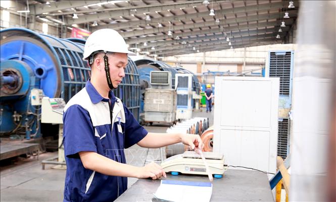 Kỹ sư Nguyễn Văn Tuân kiểm tra tỉ trọng cáp điện, một trong những hoạt động của nghiên cứu để giảm tỉ trọng lõi dẫn, giảm giá thành sản xuất cáp điện. Ảnh: Minh Thu- TTXVN