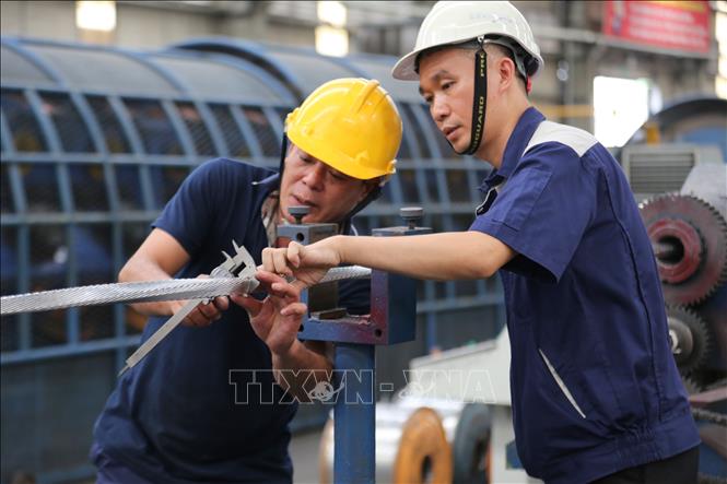 Kỹ sư Nguyễn Văn Tuân (phải) luôn sát sao trong quá trình triển khai sáng kiến để khắc phục kịp thời những kỹ thuật chưa hoàn hảo. Ảnh: Minh Thu- TTXVN