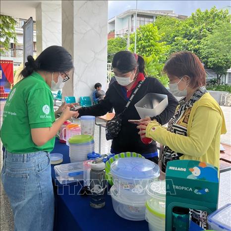 Người dân mang rác tái chế đến đổi quà trong chương trình đổi rác lấy quà do Thành Đoàn Thành phố Hồ Chí Minh phối hợp với Công ty CP Dịch vụ Xã hội MGREEN tổ chức tại Chung cư Nguyễn Thái Bình (Quận 1, Thành phố Hồ Chí Minh). Ảnh: TTXVN phát