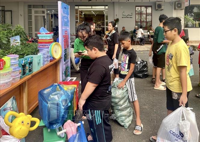 Học sinh mang rác tái chế đến đổi quà trong chương trình đổi rác lấy quà do Thành Đoàn Thành phố Hồ Chí Minh phối hợp với Công ty CP Dịch vụ Xã hội MGREEN tổ chức tại chung cư Nguyễn Thái Bình (Quận 1, Thành phố Hồ Chí Minh). Ảnh: TTXVN phát