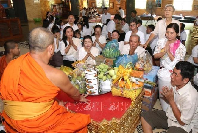 Người dân Campuchia thực hiện nghi thức cúng dường chư tăng tại tại Chùa Svay Romeat tỉnh Siem Reap. Ảnh: AKP/TTXVN phát