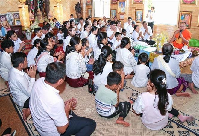 Người dân Campuchia thực hiện nghi thức cúng dường chư tăng tại tại Chùa Svay Romeat tỉnh Siem Reap. Ảnh: AKP/TTXVN phát
