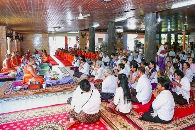 Người dân Campuchia thực hiện nghi thức cúng dường chư tăng tại tại Chùa Svay Romeat tỉnh Siem Reap. Ảnh: AKP/TTXVN phát