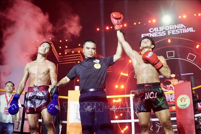 Võ sỹ Nguyễn Trần Duy Nhất (găng đỏ) xuất sắc giành đai vô địch IPCC (International Professional Combat Council) hạng 60 kg nam trước võ sỹ người Thái Lan Chaiwat Sungnoi. Ảnh: Thanh Vũ - TTXVN
