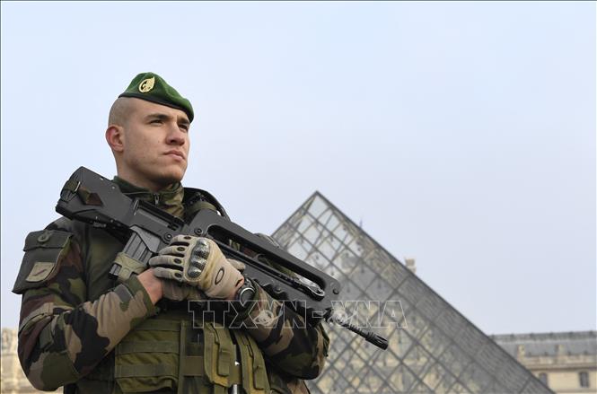 Cảnh sát gác tại lối vào Kim Tự tháp trong khuôn viên Bảo tàng Louvre ở Paris. Ảnh: AFP/TTXVN