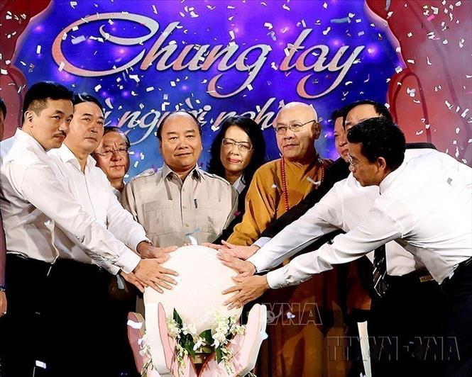 Thủ tướng Nguyễn Xuân Phúc và các đại biểu thực hiện nghi thức hưởng ứng phong trào thi đua “Cả nước chung tay vì người nghèo – Không để ai bị bỏ lại phía sau” (15/10/2017). Ảnh Nguyễn Dân - TTXVN