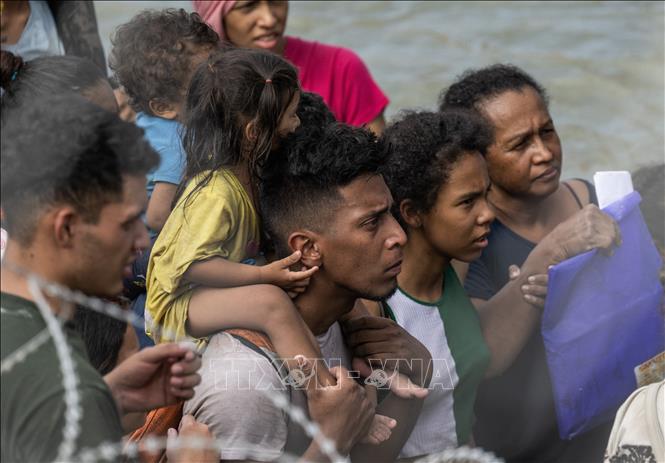 Người di cư đợi để xin nhập cư vào Mỹ  tại khu vực biên giới Mỹ- Mexico ở Eagle Pass, bang Texas, Mỹ, ngày 22/9/203. Ảnh: AFP/TTXVN