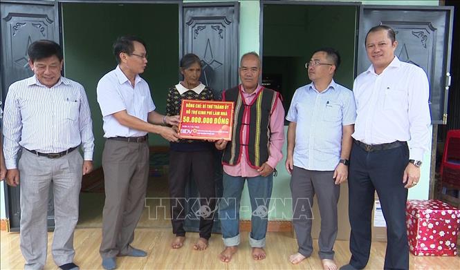 Lãnh đạo thành ủy thành phố Pleiku hỗ trợ kinh phí xây nhà cho hộ nghèo ở xã Gào. Ảnh: TTXVN phát
