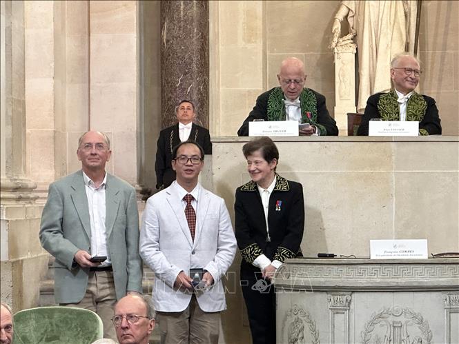 Tran Quang Hoa and his co-research Professor Marc Chardin receive their prize. VNA Photo: Nguyễn Thu Hà
