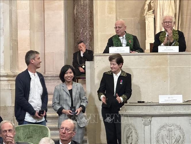 Dr. Hoang Thi Giang and Professor Stéphan Jouannic receive their prize. VNA Photo: Nguyễn Thu Hà