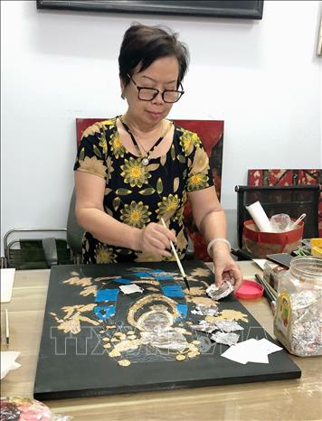 Họa sỹ Phan Thị Thanh Mai sáng tác các tác phẩm nghệ thuật. Ảnh: Phương Hà - TTXVN phát