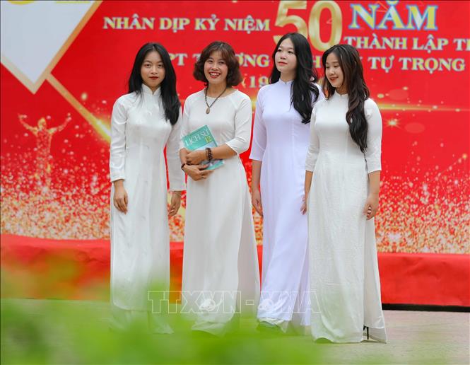 Vẻ đẹp dịu dàng của người phụ nữ toát lên trong trang phục áo dài của giáo viên, học sinh trung học khi tới trường. Ảnh: Thanh Tùng - TTXVN