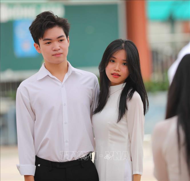 Chúng mình cùng lưu giữ lại khoảnh khắc đẹp trong tà áo dài trắng dưới nắng sân trường. Ảnh: Thanh Tùng - TTXVN