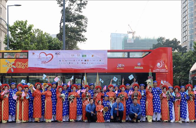 Các cặp vợ chồng thanh niên công nhân chuẩn bị tham gia phần diễu hành quanh Thành phố bằng xe buýt hai tầng. Ảnh: Hồng Giang - TTXVN