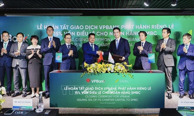 Đại diện lãnh đạo hai ngân hàng trao đổi văn kiện chứng nhận hoàn tất thương vụ phát hành cổ phiếu riêng lẻ. Ảnh: Trần Việt - TTXVN 