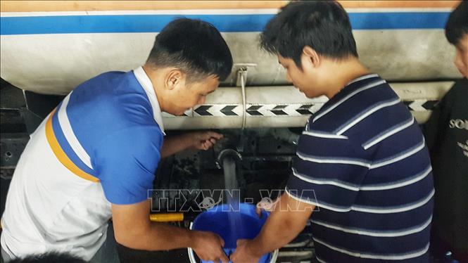 Người dân Khu đô thị Thanh Hà lấy nước từ xe chở nước sạch, tối 20/10. Ảnh: Phan Tuấn Anh - TTXVN