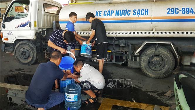 Gần 20h, người dân các tòa nhà HH2E và HH2D Khu đô thị Thanh Hà vẫn đang lấy nước. Ảnh: Phan Tuấn Anh - TTXVN