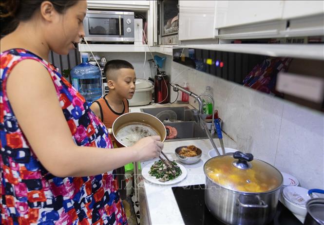 Sau nhiều ngày mất nước, đến 20/10, chị Nguyễn Thị Thanh Lưu (tòa HH2E) mới tự nấu ăn tại gia đình. Ảnh: Hoàng Hiếu - TTXVN
