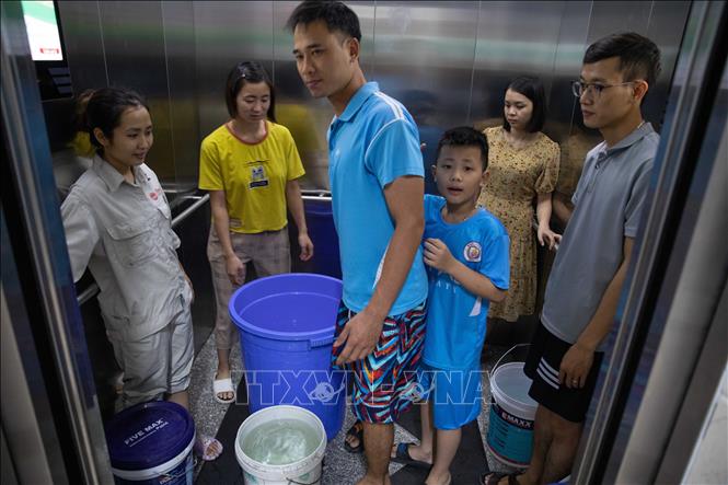 Người dân dùng thang máy để đưa nước lên từng hộ. Ảnh: Hoàng Hiếu - TTXVN 