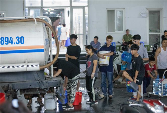 Người dân tòa HH2E và HH2D khu đô thị Thanh Hà xếp hàng chờ lấy nước, tối 20/10. Ảnh: Hoàng Hiếu - TTXVN