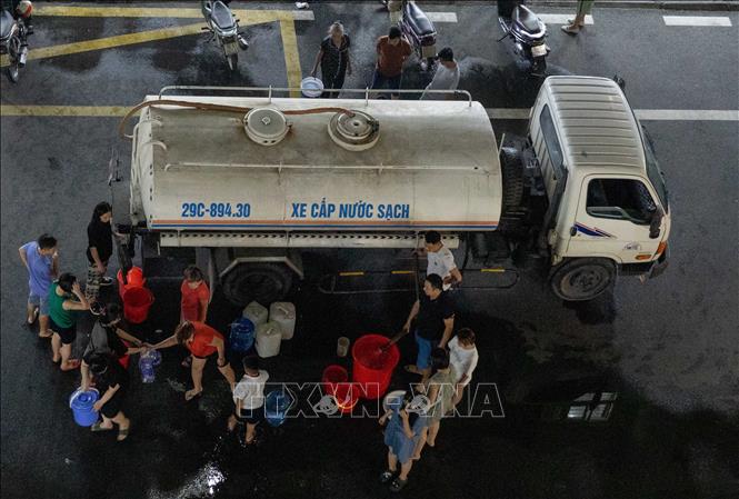 Xe nước sạch đến các hộ dân sinh sống tại Khu đô thị Thanh Hà tối 20/10. Ảnh: Hoàng Hiếu - TTXVN
