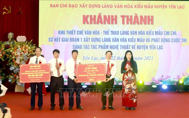 Bí thư Tỉnh ủy Vĩnh Phúc  Hoàng Thị Thúy Lan và Chủ tịch UBND tỉnh Vĩnh Phúc (phải ảnh) tặng sách cho thư viện thôn Chi Chỉ và  tặng thưởng lãnh đạo huyện Yên Lạc, lãnh đạo xã Đồng Cương đã đạt thành tích về đích sớm xây dựng làng văn hóa kiểu mẫu. Ảnh: Hoàng Hùng – TTXVN