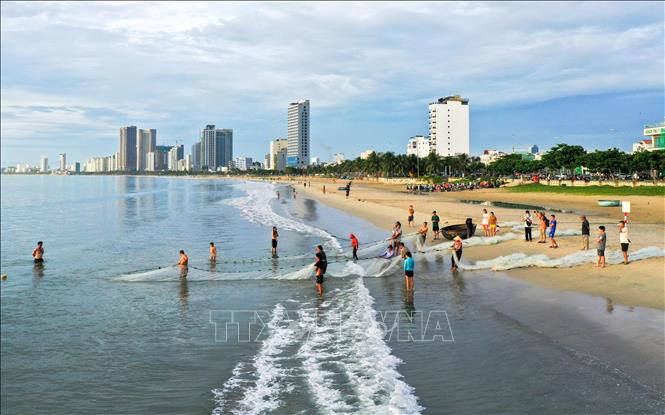 Người dân, du khách đứng xem và có thể tham gia trải nghiệm kéo lưới cùng ngư dân. Ảnh: Trần Lê Lâm – TTXVN 