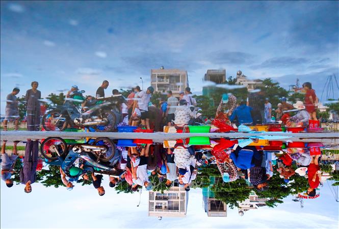 A reflection of the colourful “hustling market”. VNA Photo: Trần Lê Lâm