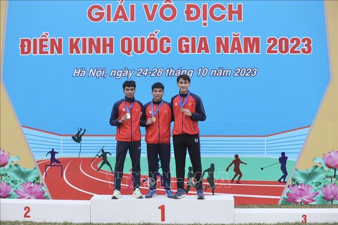 Ban tổ chức trao Huy chương nội dung 400m nam, HCV Trần Đình Sơn (giữa, Hà Tĩnh, 46 giây 88), HCB Lê Ngọc Phúc (bên trái, Hà Tĩnh, 47 giây 27), HCĐ Trần Nhật Hoàng (bên phải, 47 giây 63). Ảnh: Minh Quyết - TTXVN 
