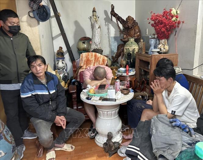 Các đối tượng bị bắt giữ cùng tang vật tại nhà trọ trên đường Trần Phú, thành phố Đà Lạt. Ảnh: TTXVN phát