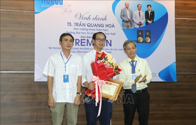 Đại diện Công đoàn trường tặng hoa chúc mừng Tiến sĩ Trần Quang Hóa. Ảnh: Tường Vi - TTXVN. 