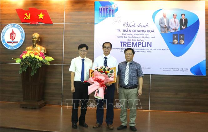 Lãnh đạo nhà trường tặng giấy khen và hoa chúc mừng Tiến sĩ Trần Quang Hóa. Ảnh: Tường Vi - TTXVN. 