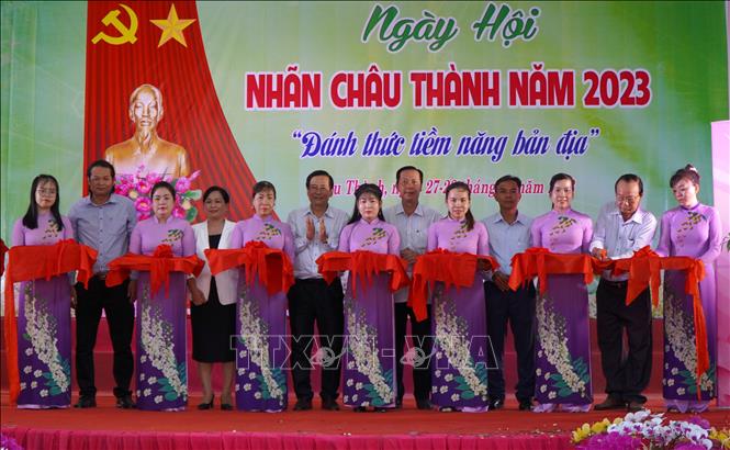 Các đại biểu thực hiện nghi thức cắt băng khai mạc Ngày hội Nhãn Châu Thành. Ảnh: Nhựt An - TTXVN
