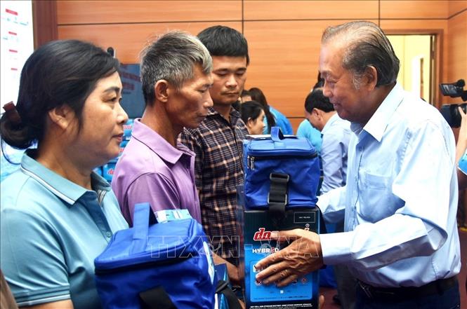 Nguyên Ủy viên Bộ Chính trị, nguyên Phó Thủ tướng Thường trực Chính phủ Trương Hòa Bình trao quà cho ngư dân trên địa bàn tỉnh Quảng Bình. Ảnh: Võ Dung - TTXVN