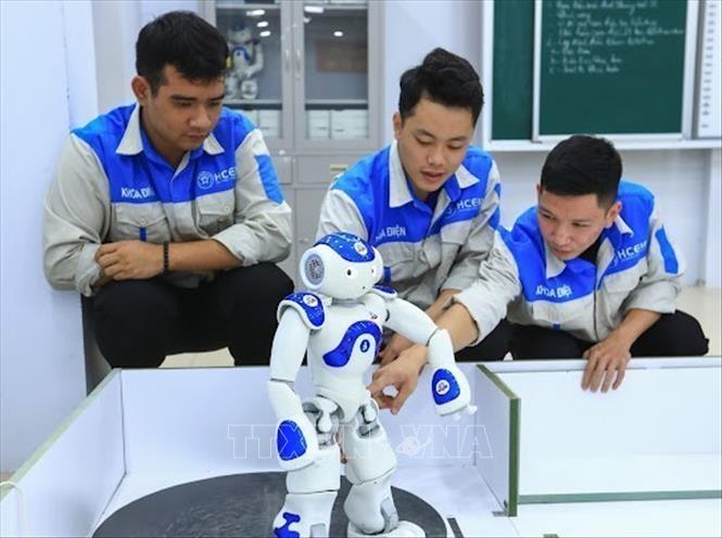 Sinh viên Lớp cơ điện tử 15 tự lập trình điều khiển các hoạt động robot. Ảnh: Hoàng Hiếu – TTXVN
