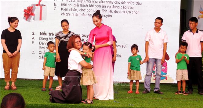 Diễn giả chương trình hướng dẫn, chia sẻ cách ôm con đúng cách và thể hiện được tình yêu thương của phụ huynh với con em mình. Ảnh: Võ Dung - TTXVN