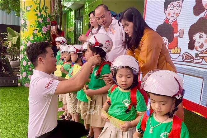 Trao tặng mũ bảo hiểm và các phần quà cho các em tham gia chương trình. Ảnh: Võ Dung - TTXVN