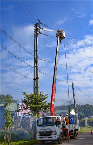 Công nhân Điện lực Mường Chà (tỉnh Điện Biên) rửa sứ hotline. Ảnh: Xuân Tư – TTXVN