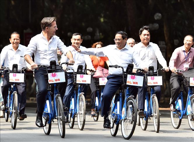 Prime Minister Pham Minh Chinh and his Dutch counterpart Mark Rutte during their cycling tour. VNA Photo