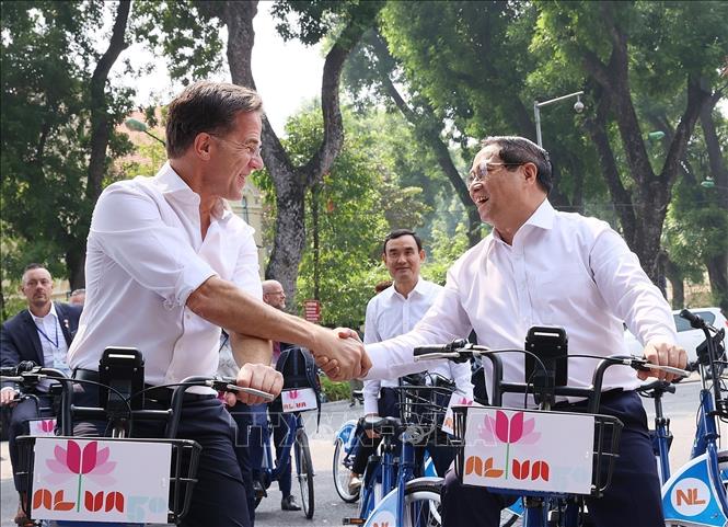 Prime Minister Pham Minh Chinh and his Dutch counterpart Mark Rutte on their cycling tour. VNA Photo