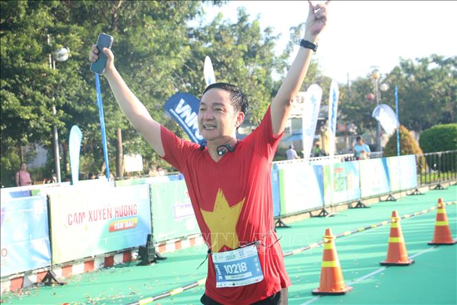 Vận động viên tham gia giải chạy Bepharco Bến Tre Marathon 2023 trong trang phục cờ đỏ sao vàng hào hứng về đích. Ảnh: Chương Đài - TTXVN