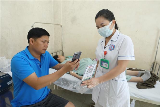 Hướng dẫn thanh toán điện tử không dùng tiền mặt cho người nhà bệnh nhân tại Trung tâm Y tế huyện Hữu Lũng (Lạng Sơn). Ảnh: Anh Tuấn – TTXVN