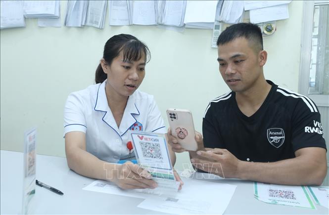 Hướng dẫn thanh toán điện tử không dùng tiền mặt cho bệnh nhân, người nhà bệnh nhân tại Trung tâm Y tế huyện Hữu Lũng (Lạng Sơn). Ảnh: Anh Tuấn – TTXVN